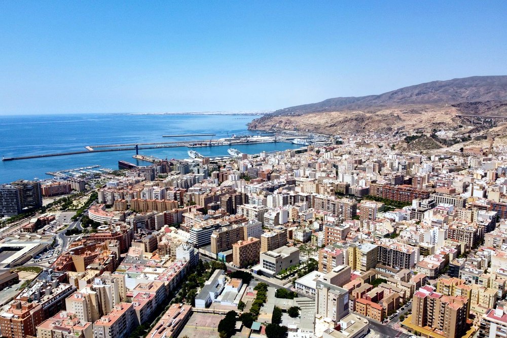 Vista aérea de Almería con el puerto y las montañas al fondo, escenario de actividades de team building para empresas
