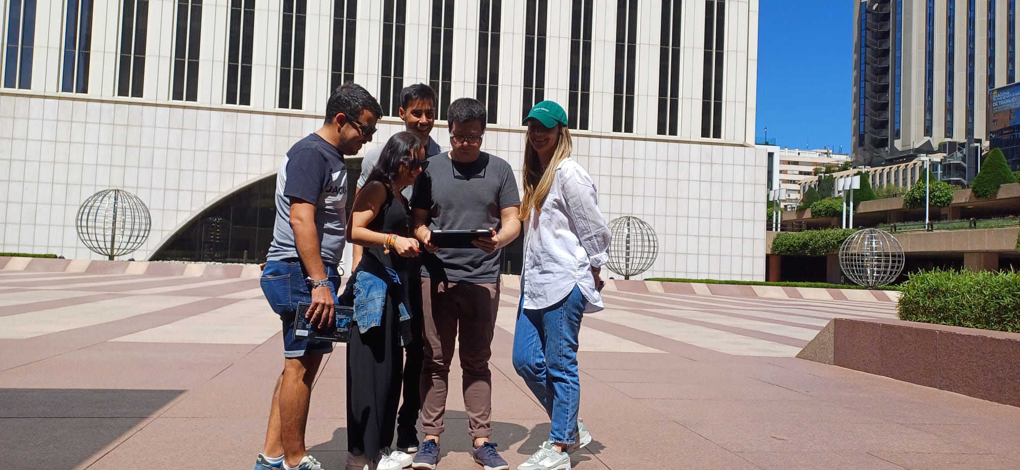Equipo de empresa jugando al Street Escape con tablets junto a Torre Picasso, Madrid